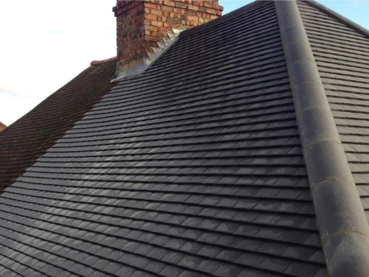 Close-up of a brick chimney with fresh lead flashing on a tiled roof