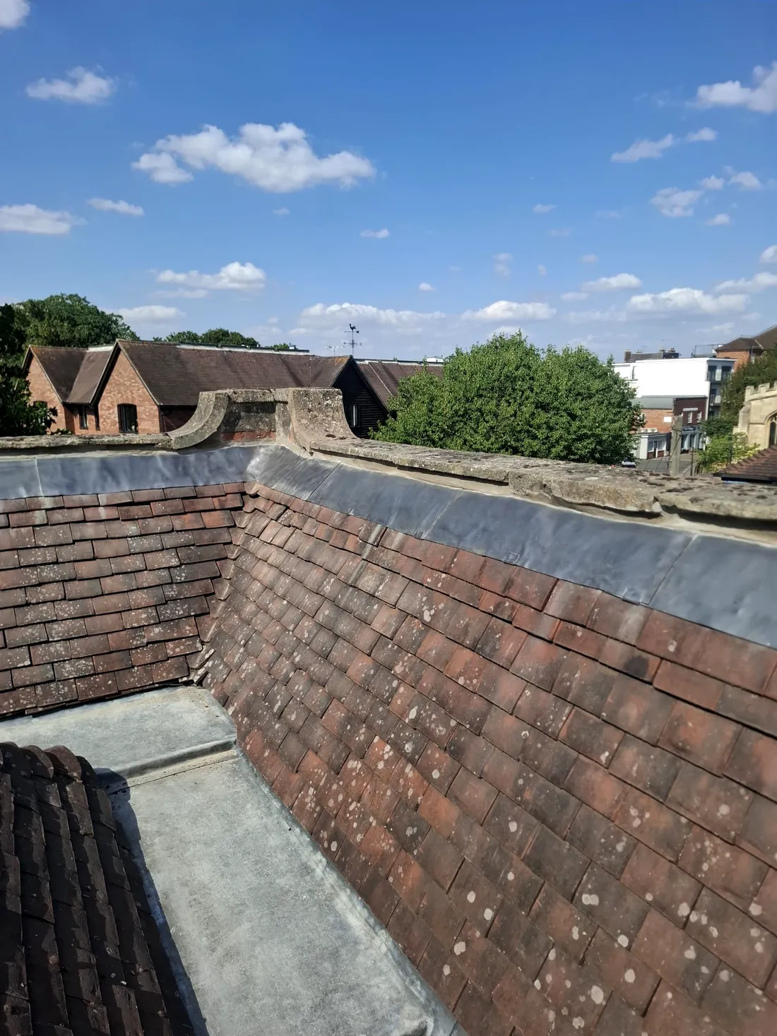 A heritage clay tiled roof with fresh leadwork to the parapet by Tammat Group