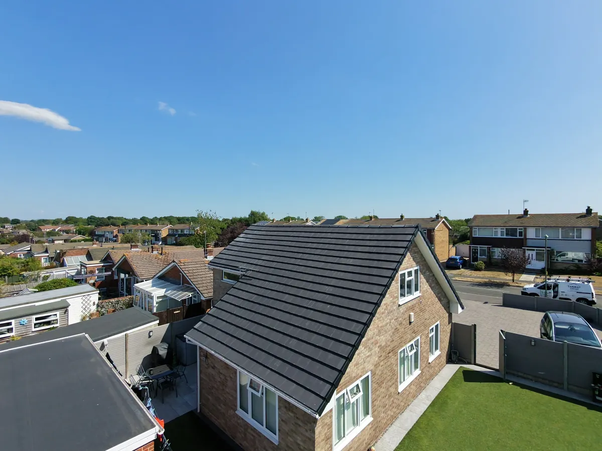 A completed grey tiled re-roof on a detached house by Tammat Group