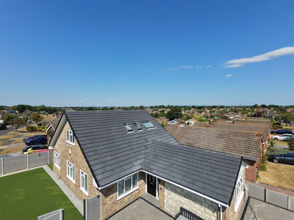 A completed grey tiled re-roof on a detached house by Tammat Group