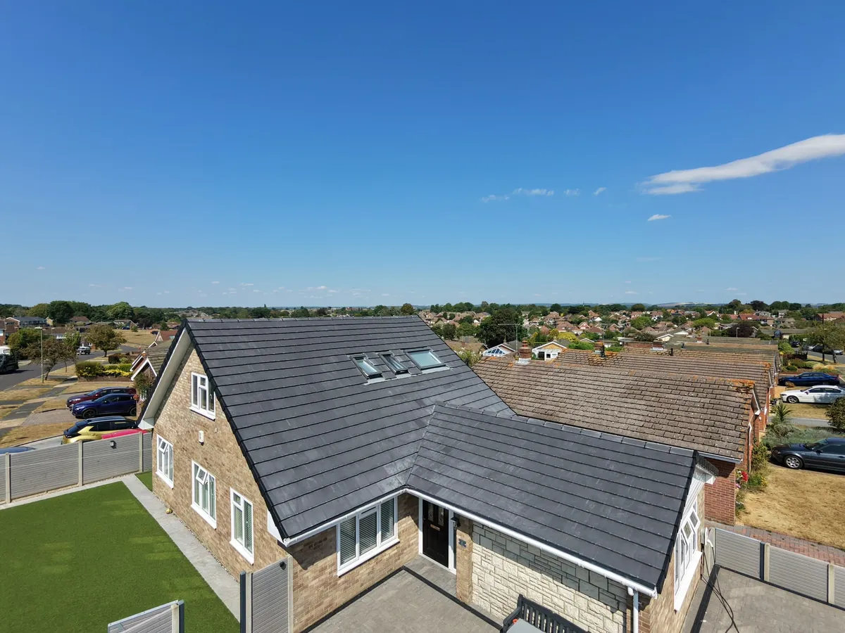 A full grey tiled re-roof with rooflights on a detached house by Tammat Group