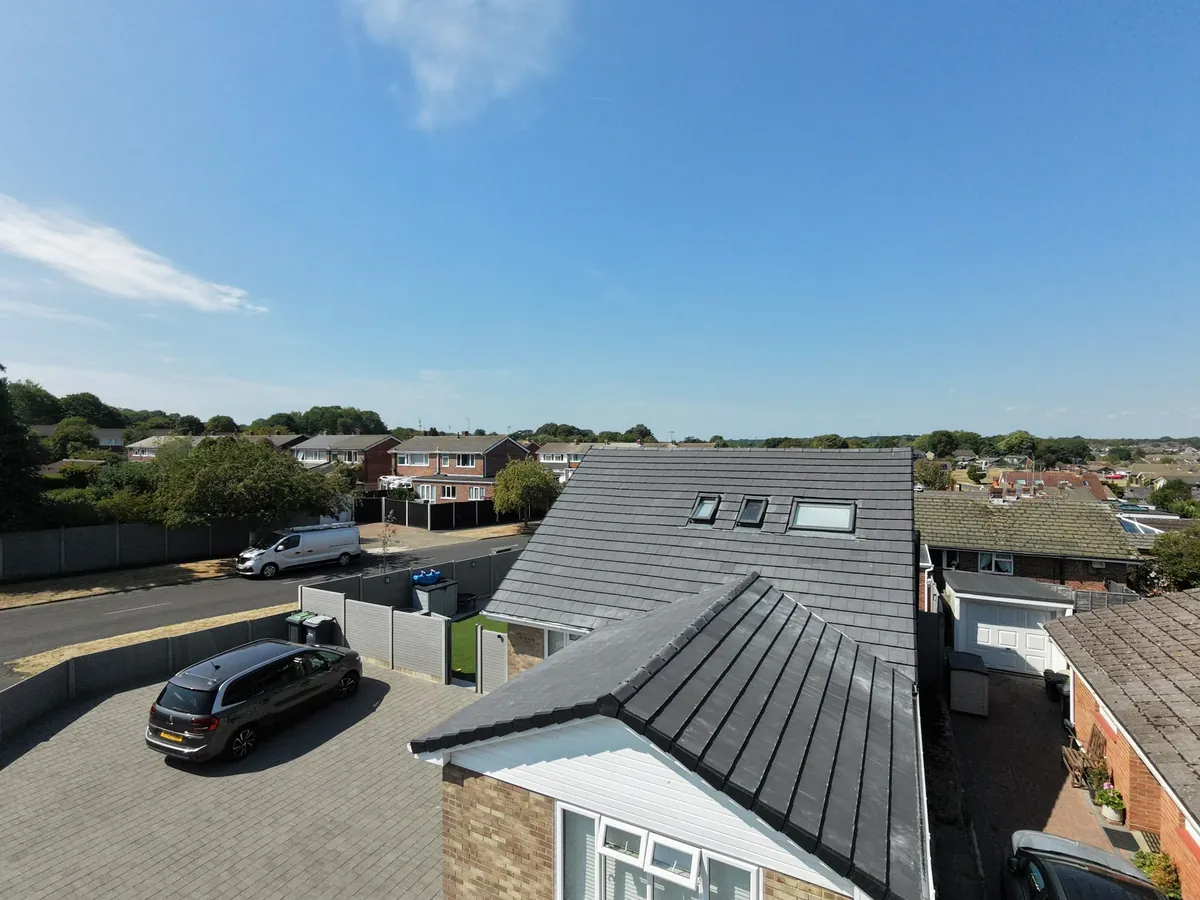 A hipped grey tiled re-roof with rooflights by Tammat Group