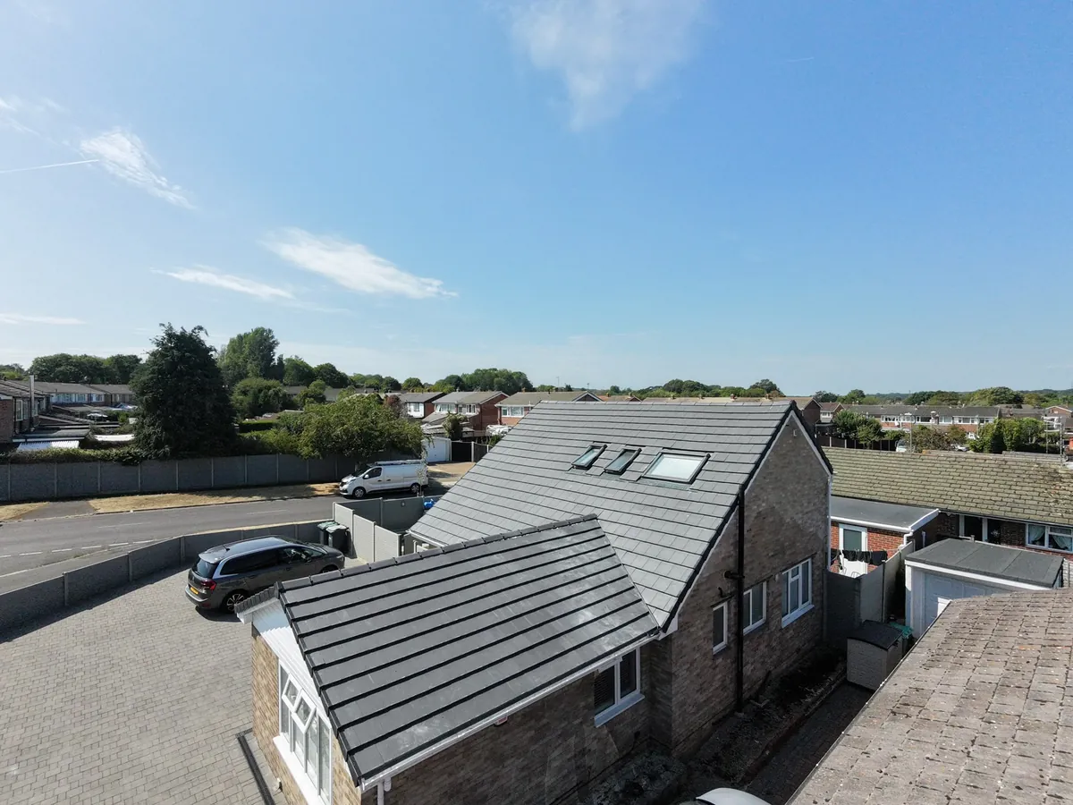 A new grey tiled roof with rooflights by Tammat Group